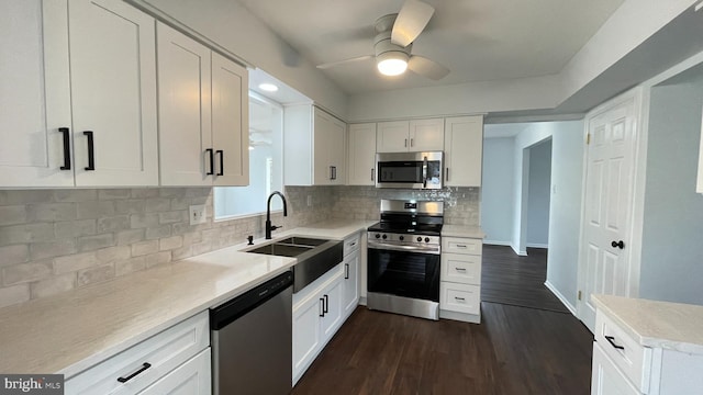 kitchen with sink, white cabinets, dark wood-type flooring, and appliances with stainless steel finishes