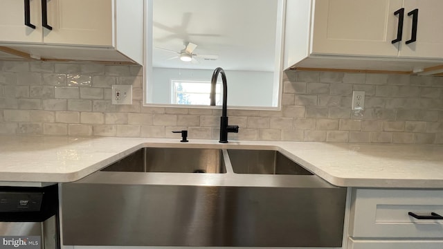 kitchen with white cabinets, sink, stainless steel dishwasher, decorative backsplash, and light stone counters