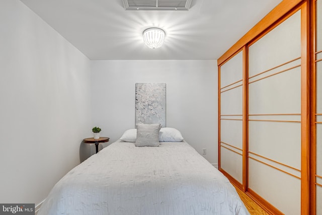 bedroom with visible vents and wood finished floors