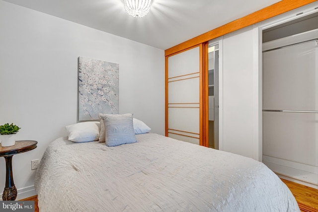 bedroom with a closet, baseboards, and wood finished floors