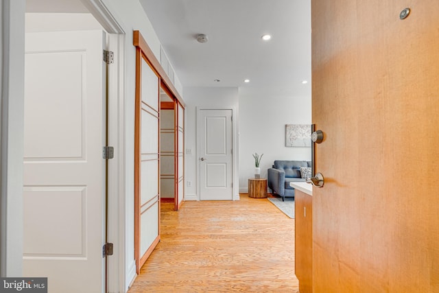 hallway featuring light wood-type flooring and recessed lighting