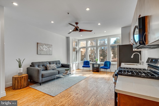 interior space featuring recessed lighting, baseboards, ceiling fan, and light wood finished floors