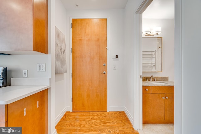 doorway with a sink and baseboards