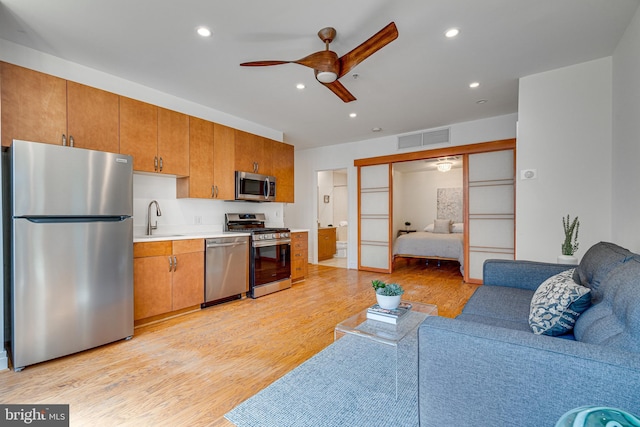 kitchen with stainless steel appliances, open floor plan, visible vents, and a sink