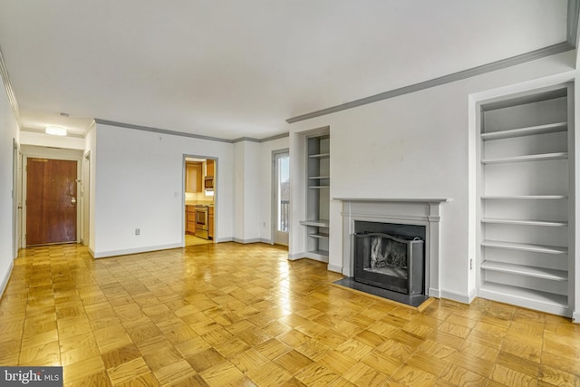 unfurnished living room with built in features, ornamental molding, and light parquet flooring