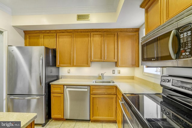 kitchen featuring sink, light tile patterned floors, ornamental molding, and appliances with stainless steel finishes