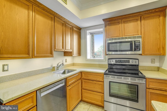 kitchen with appliances with stainless steel finishes, light stone counters, crown molding, sink, and light tile patterned floors