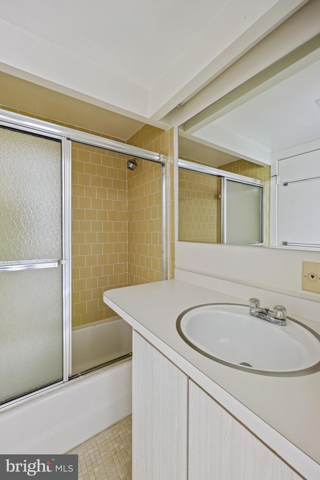 bathroom with tile patterned flooring, vanity, and enclosed tub / shower combo