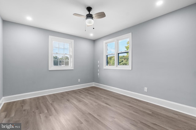 spare room featuring light hardwood / wood-style floors, a wealth of natural light, and ceiling fan