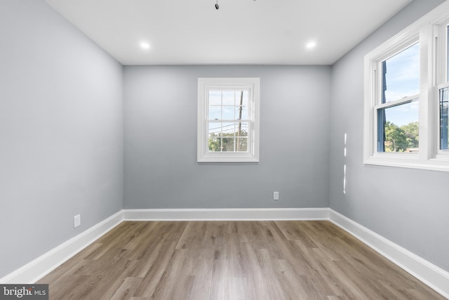 spare room with a healthy amount of sunlight and light hardwood / wood-style floors