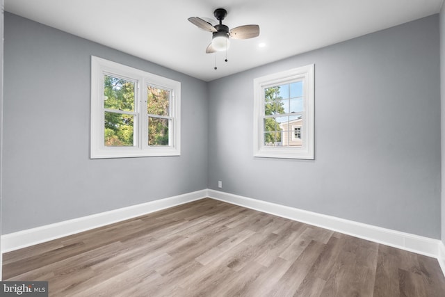 empty room with ceiling fan and light hardwood / wood-style floors