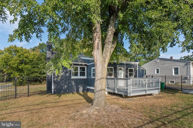 back of property with a wooden deck and a yard