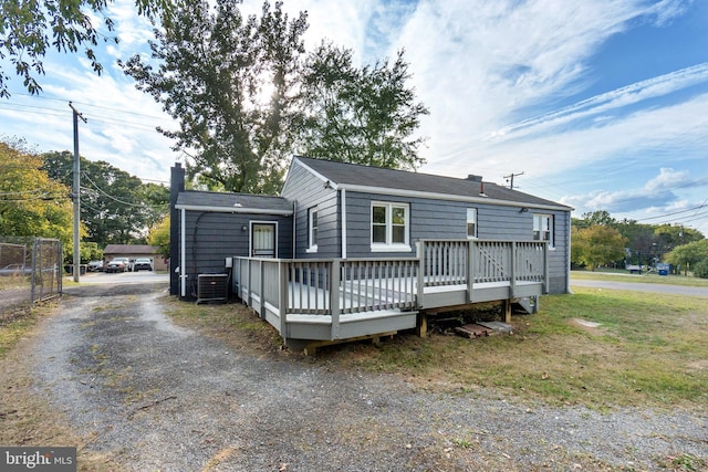 rear view of property with cooling unit and a wooden deck