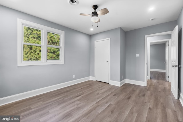 unfurnished bedroom featuring ceiling fan, a closet, and light wood-type flooring