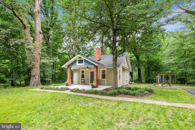 view of front of property with ceiling fan, covered porch, and a front yard