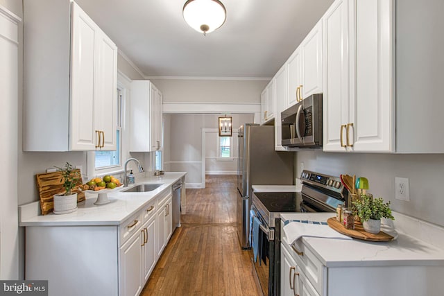 kitchen featuring sink, dark hardwood / wood-style floors, appliances with stainless steel finishes, light stone counters, and white cabinetry