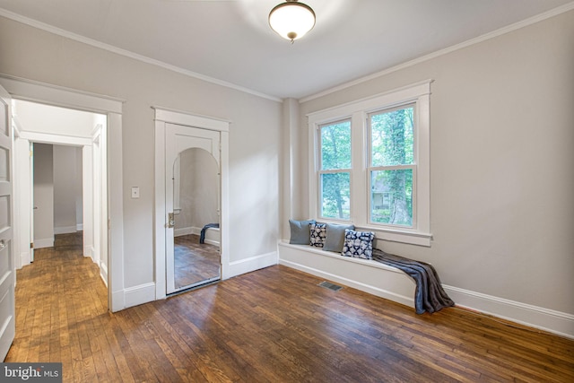 unfurnished bedroom featuring crown molding, a closet, and dark wood-type flooring