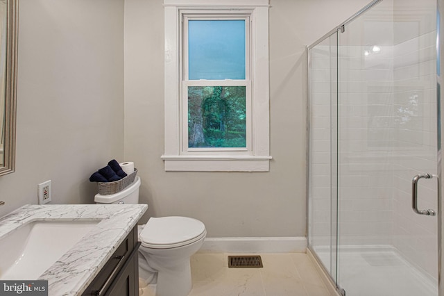 bathroom with vanity, toilet, and a shower with door