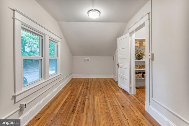 bonus room with lofted ceiling and light wood-type flooring