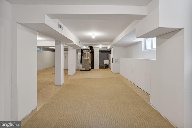 basement with light colored carpet and heating unit