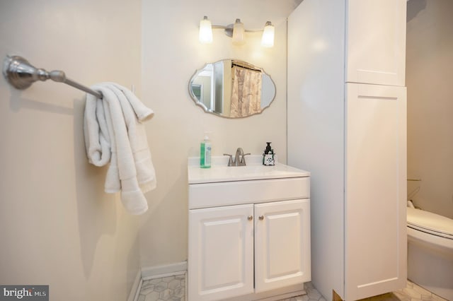 bathroom with tile patterned flooring, vanity, and toilet