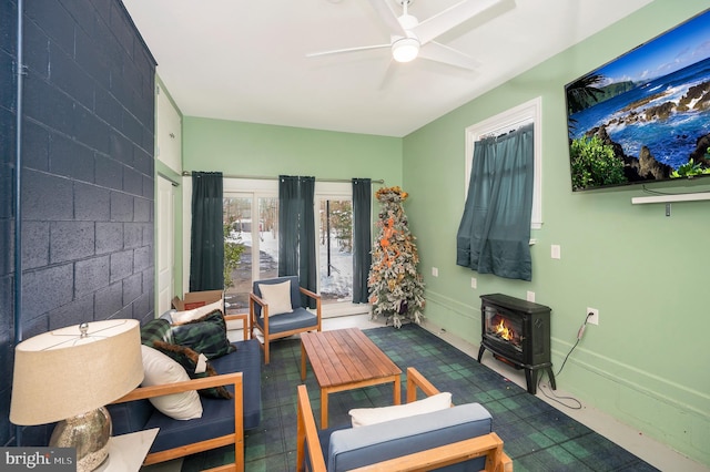 living room with a wood stove and ceiling fan