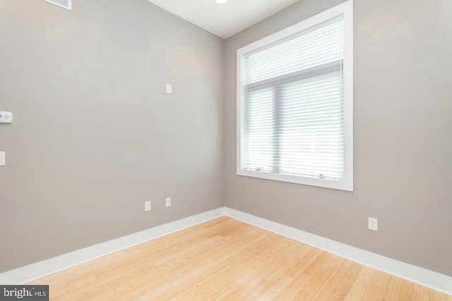 unfurnished room with hardwood / wood-style flooring