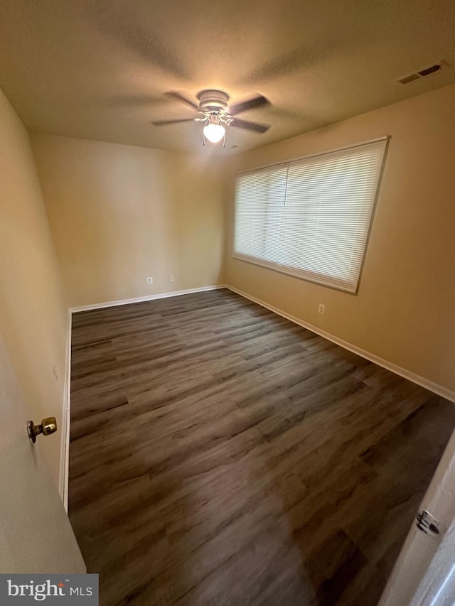 empty room featuring ceiling fan and dark hardwood / wood-style flooring