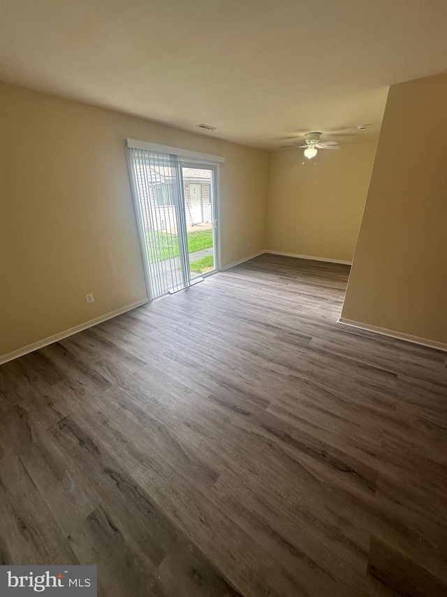 spare room with dark hardwood / wood-style floors and ceiling fan