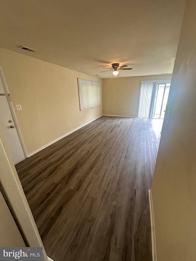 empty room with dark hardwood / wood-style floors and ceiling fan