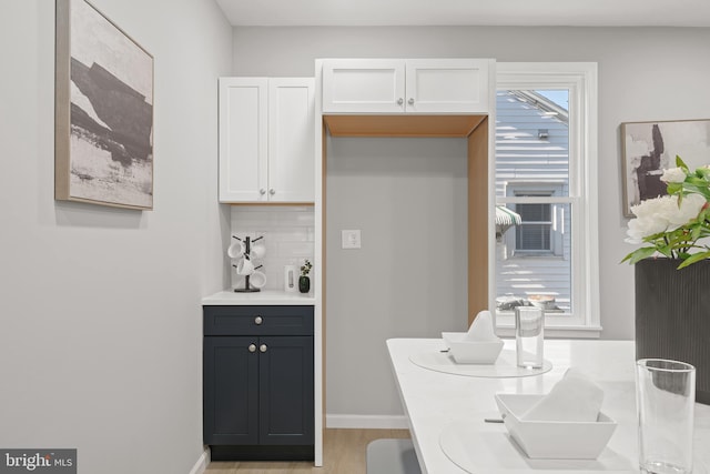 kitchen featuring white cabinetry, light hardwood / wood-style flooring, and tasteful backsplash