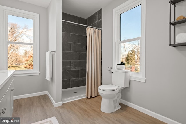 bathroom featuring toilet, a shower with shower curtain, and hardwood / wood-style flooring