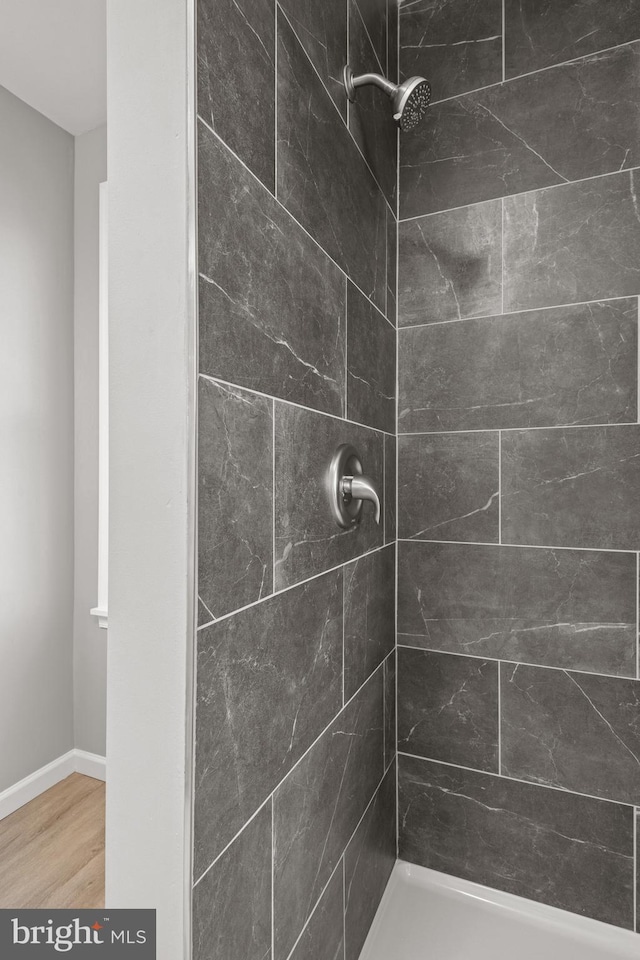 bathroom with wood-type flooring and tiled shower