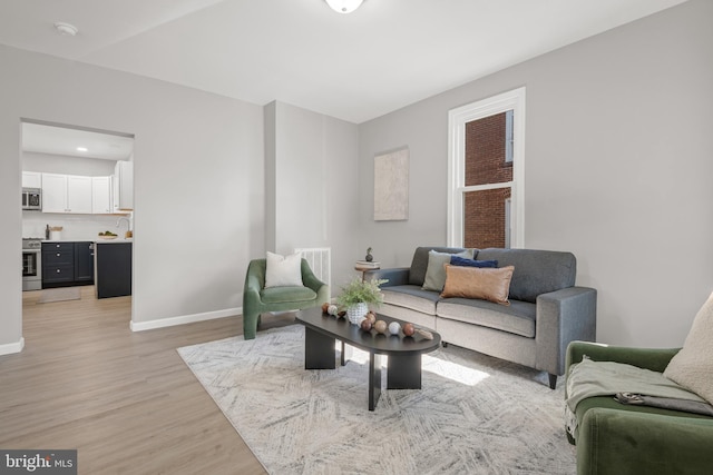 living room featuring light wood-type flooring and sink