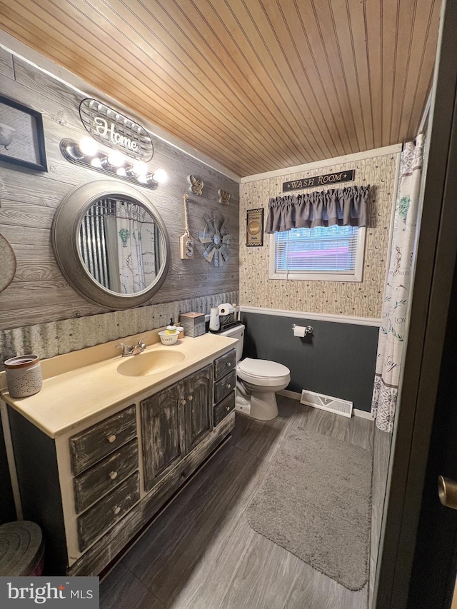 bathroom featuring hardwood / wood-style floors, vanity, wooden walls, toilet, and wood ceiling