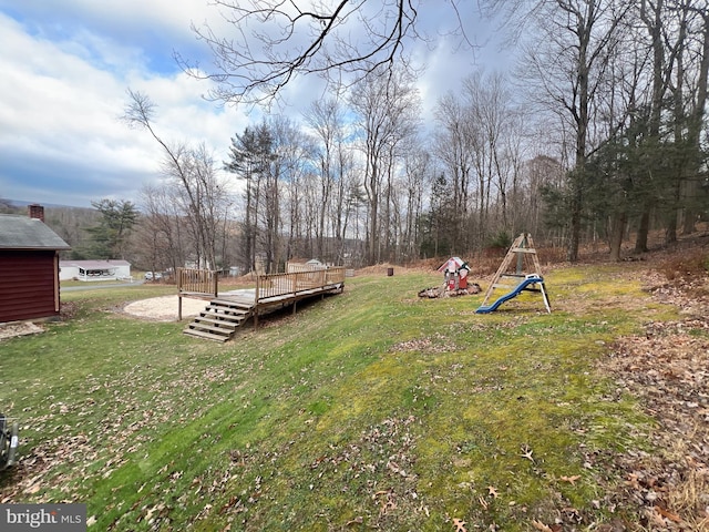 view of yard featuring a playground and a wooden deck