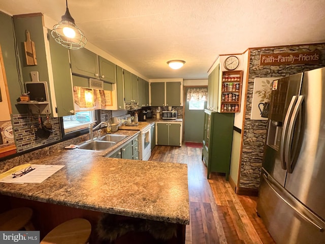 kitchen featuring sink, dark wood-type flooring, stainless steel appliances, green cabinets, and kitchen peninsula