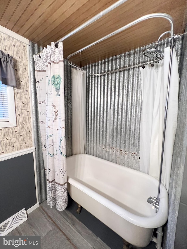 bathroom featuring wood-type flooring, wood ceiling, wooden walls, and shower / tub combo