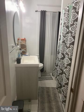 bathroom with toilet, vanity, and walk in shower