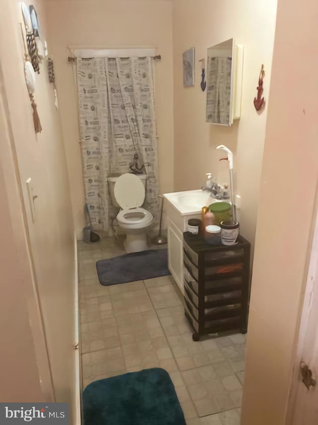 bathroom featuring toilet and vanity