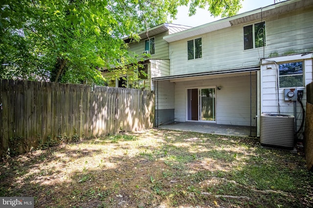 rear view of house with central AC unit and a patio