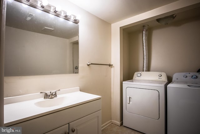 clothes washing area featuring washing machine and dryer, light tile patterned floors, and sink