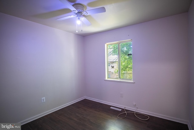 empty room with ceiling fan and dark hardwood / wood-style flooring