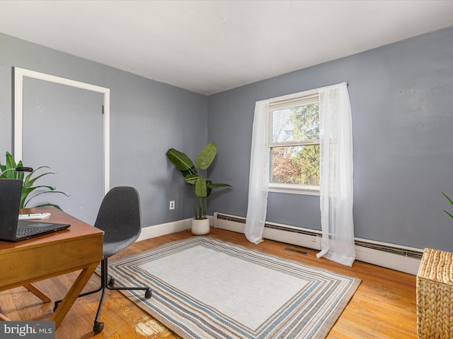 office area featuring a baseboard radiator and hardwood / wood-style flooring