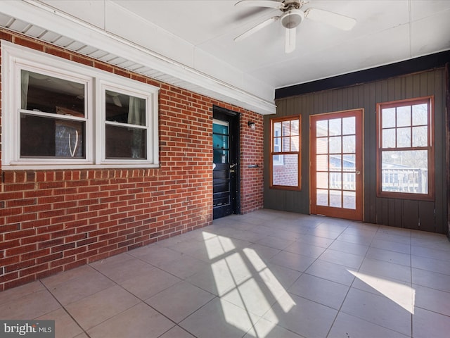 unfurnished sunroom with ceiling fan