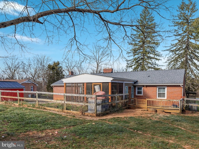 back of property with a sunroom and a yard