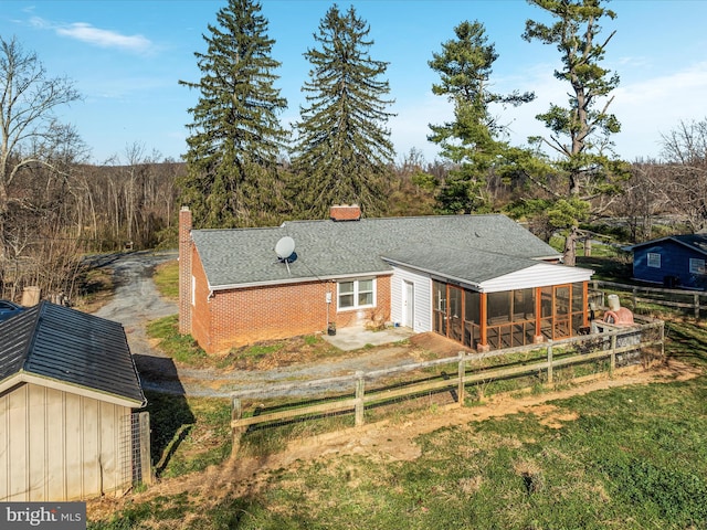 rear view of property with an outdoor structure