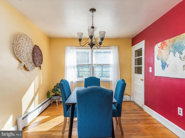 dining space featuring baseboard heating, a chandelier, and wood-type flooring