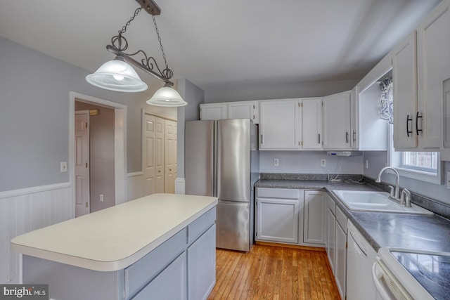 kitchen featuring white cabinets, stainless steel refrigerator, and white dishwasher