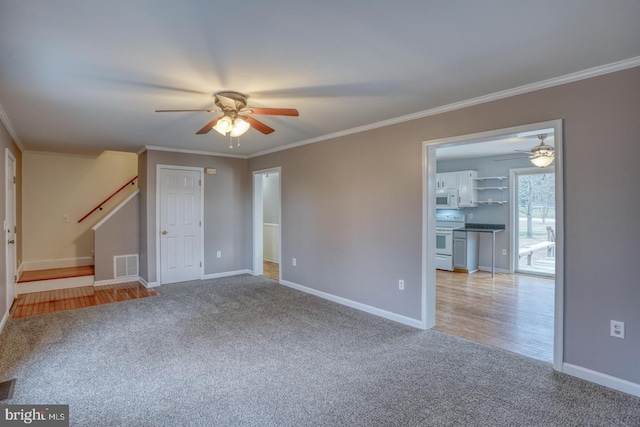 empty room featuring light carpet, ceiling fan, and crown molding